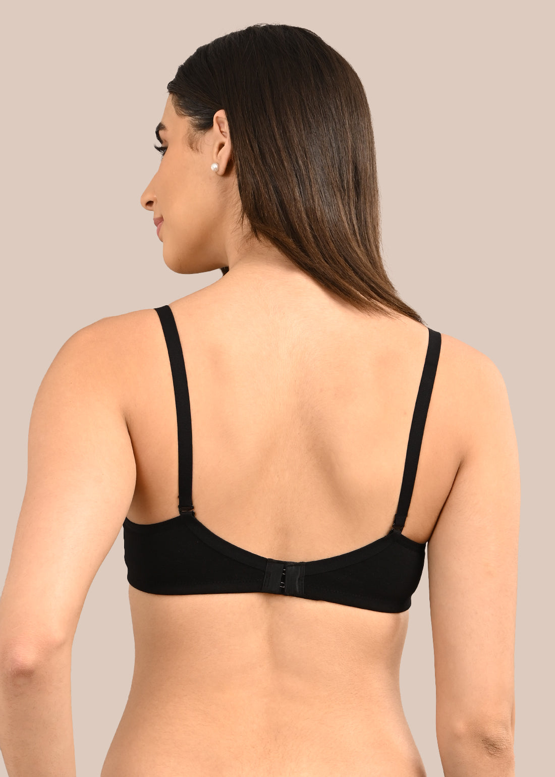Woman wearing a bra against a neutral background