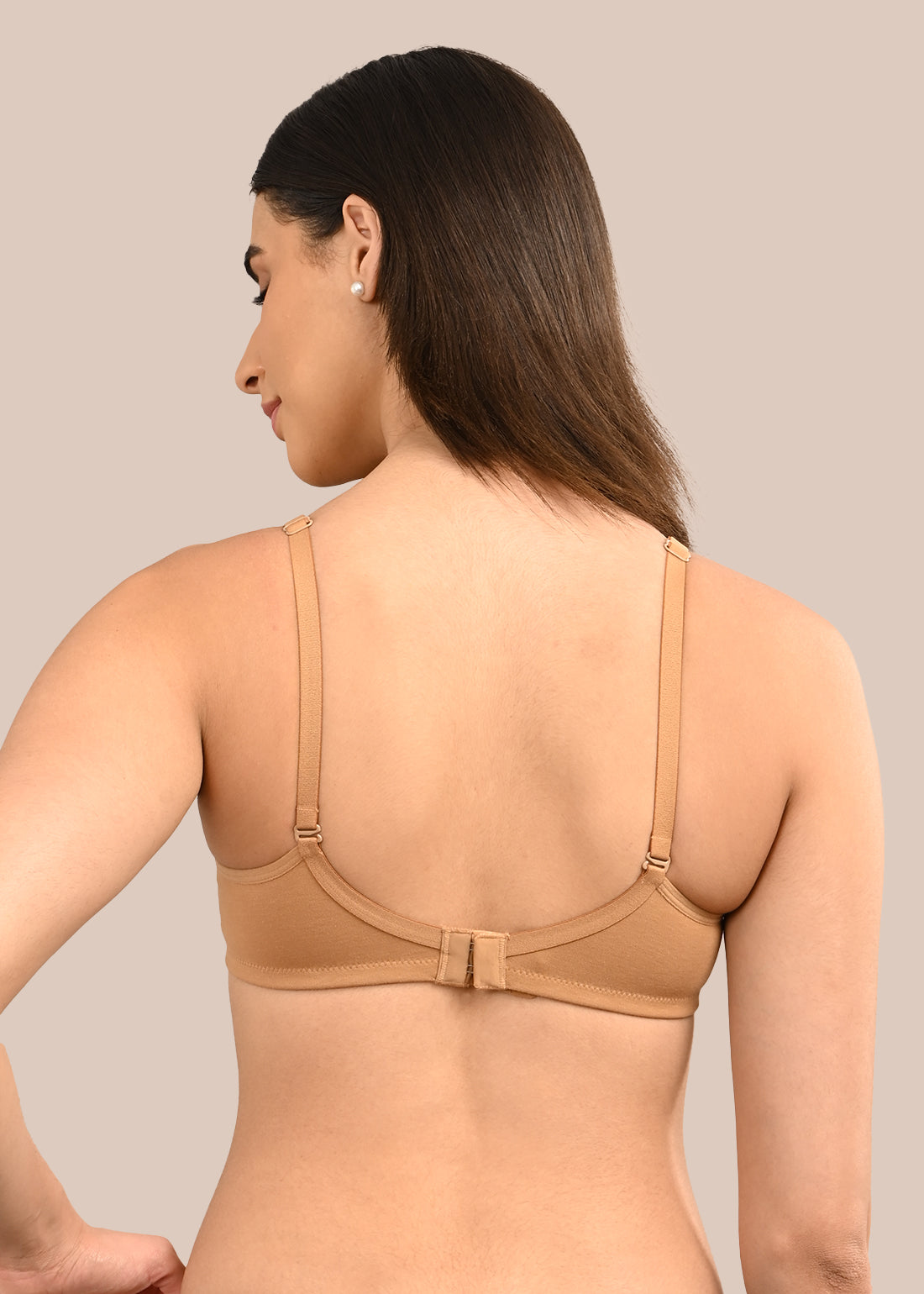 Woman wearing a bra against a neutral background