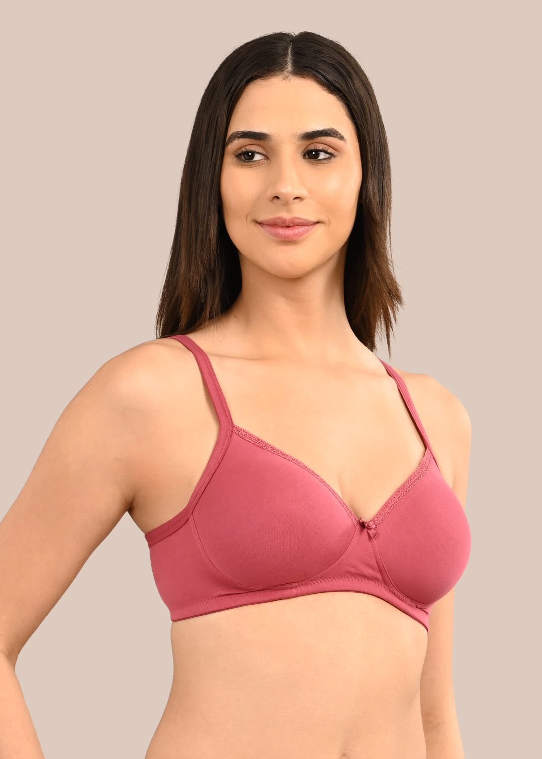 Woman wearing a bra against a neutral background