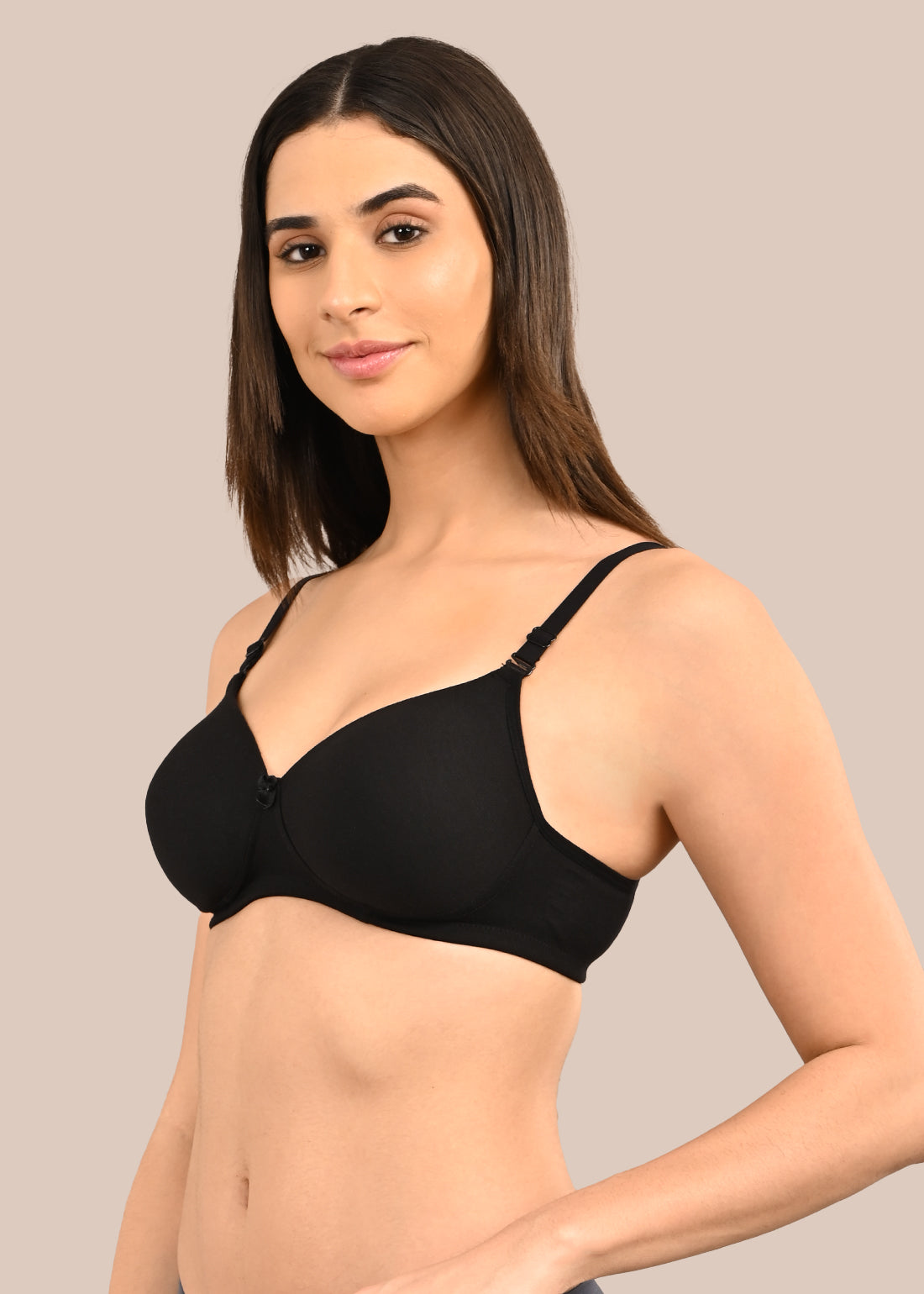 Woman wearing a bra against a neutral background