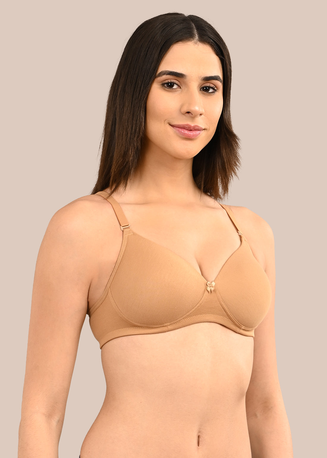 Woman wearing a bra against a neutral background