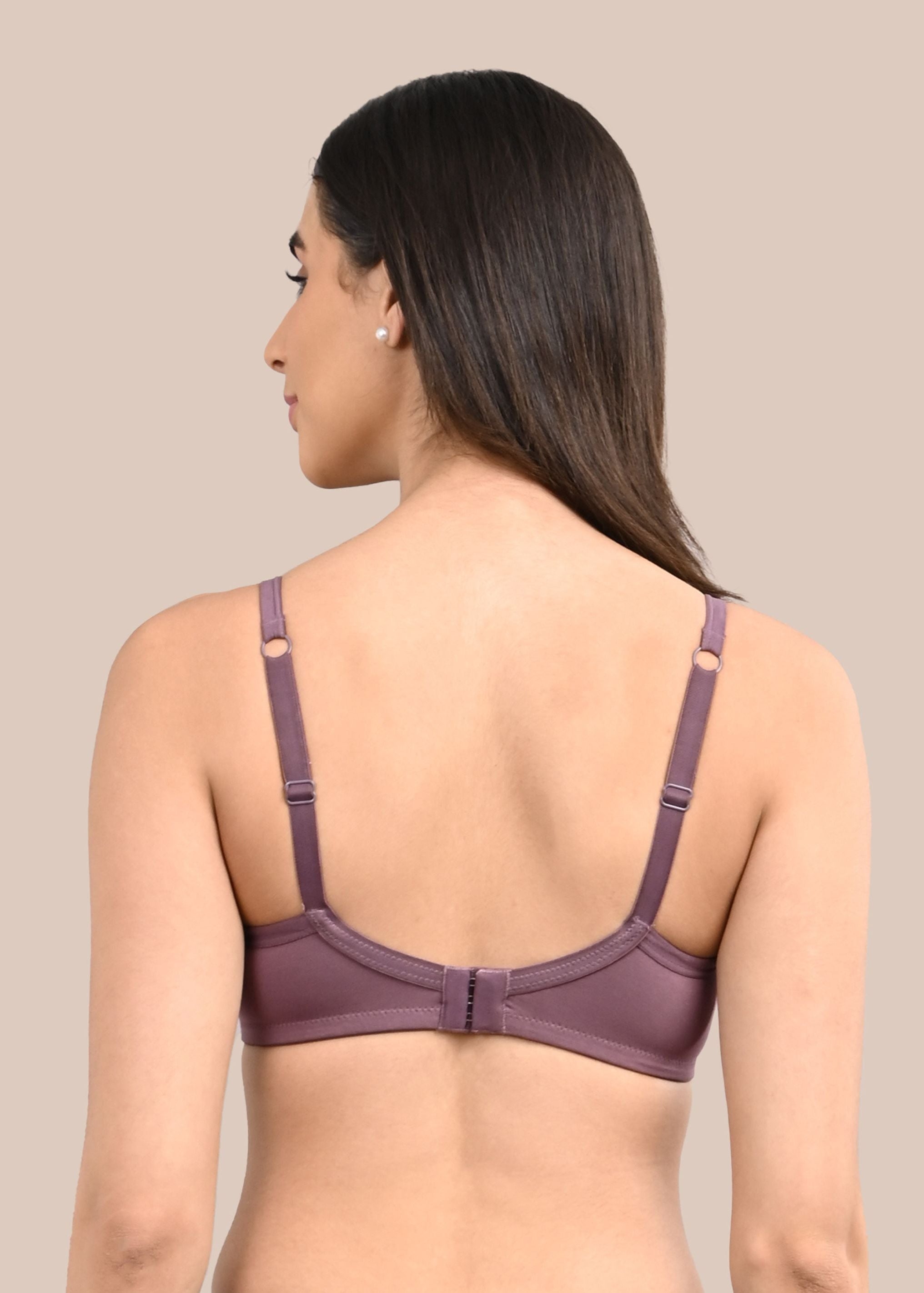 Woman wearing a bra against a neutral background