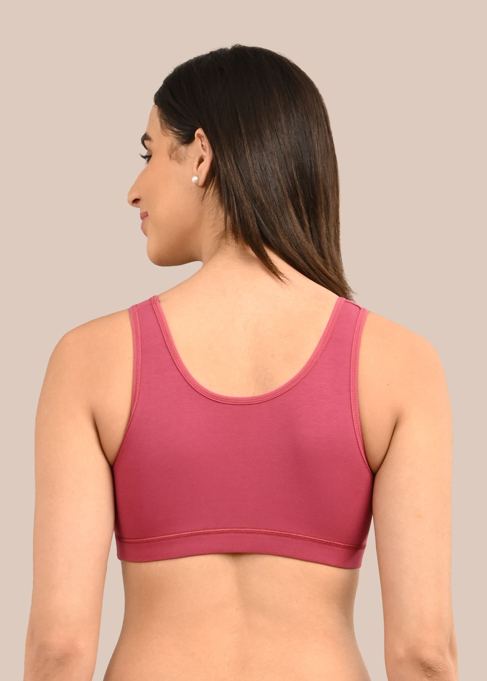 Woman wearing a bra against a neutral background