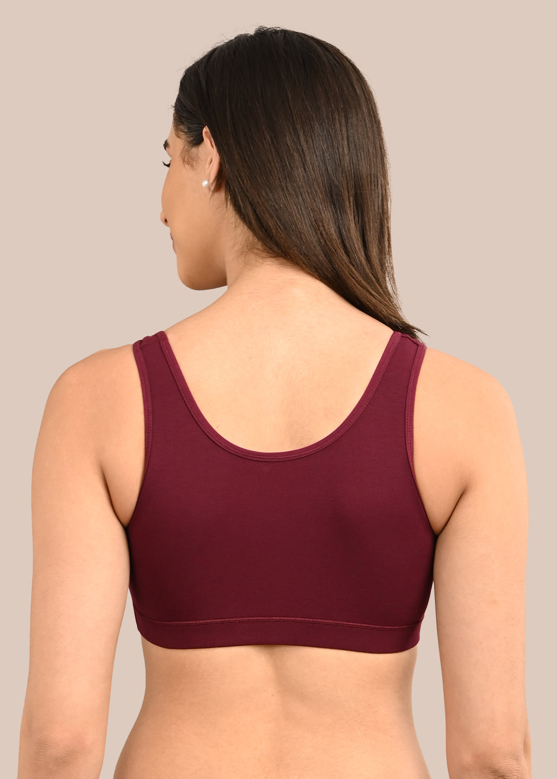 Woman wearing a bra against a neutral background