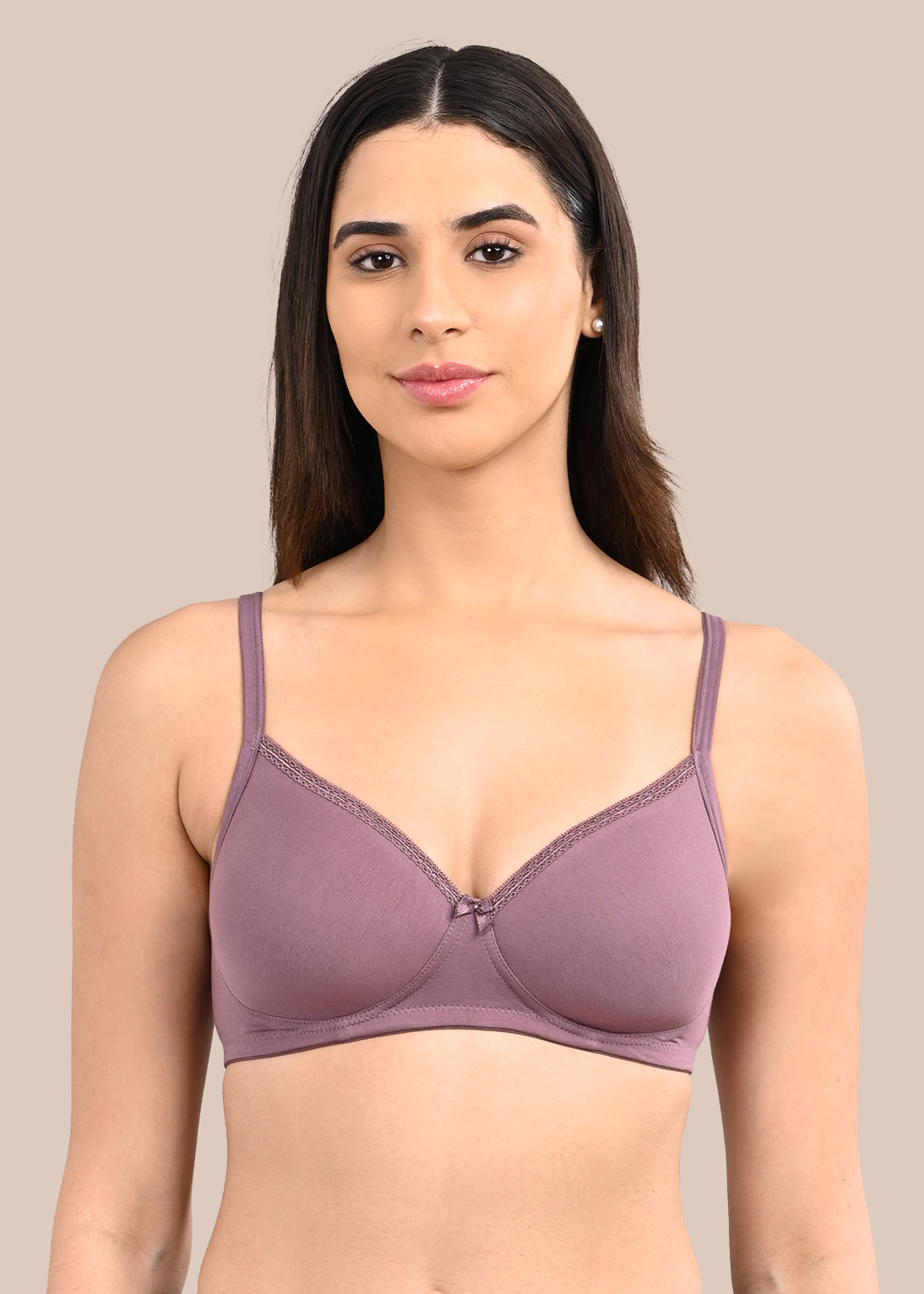 Woman wearing a bra against a neutral background