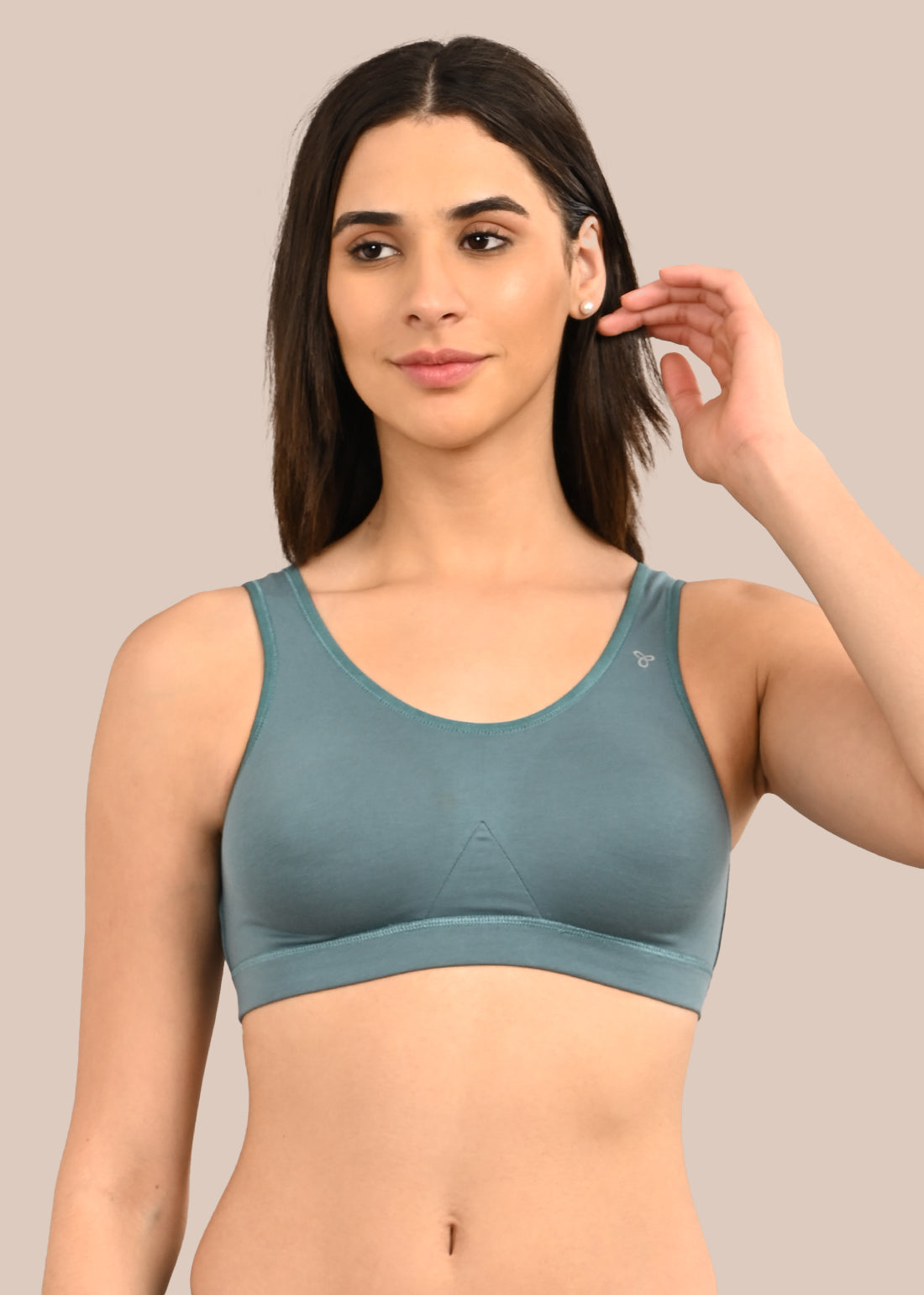 Woman wearing a bra against a neutral background