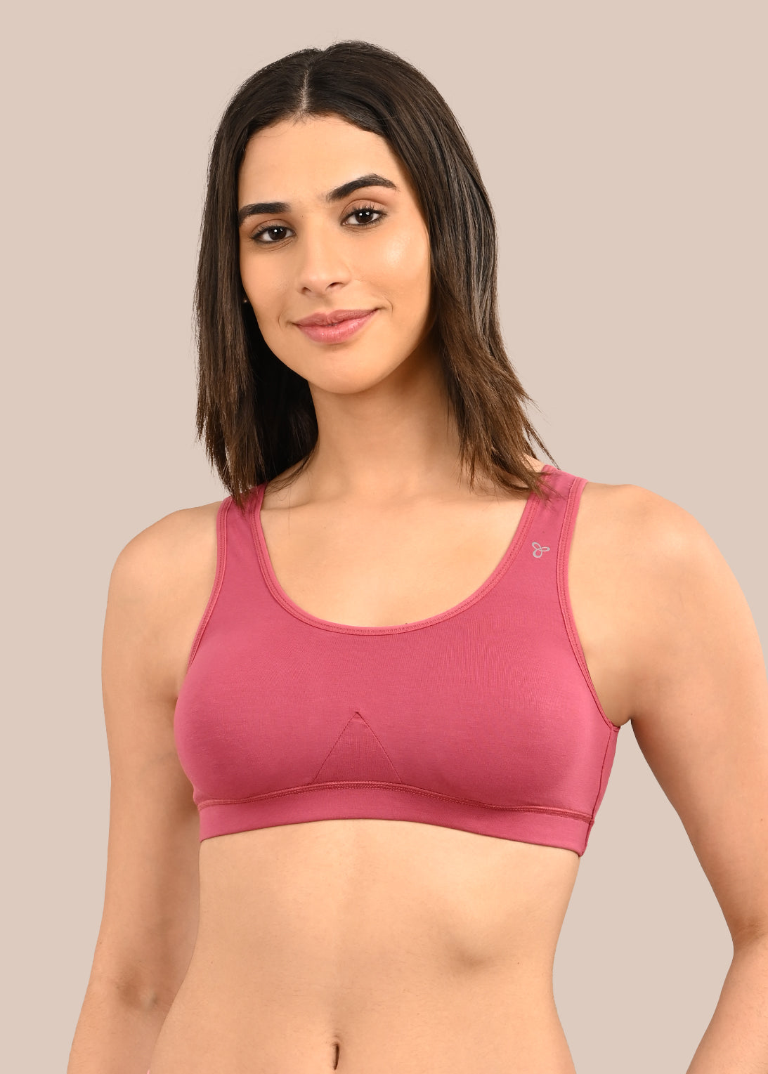 Woman wearing a bra against a neutral background
