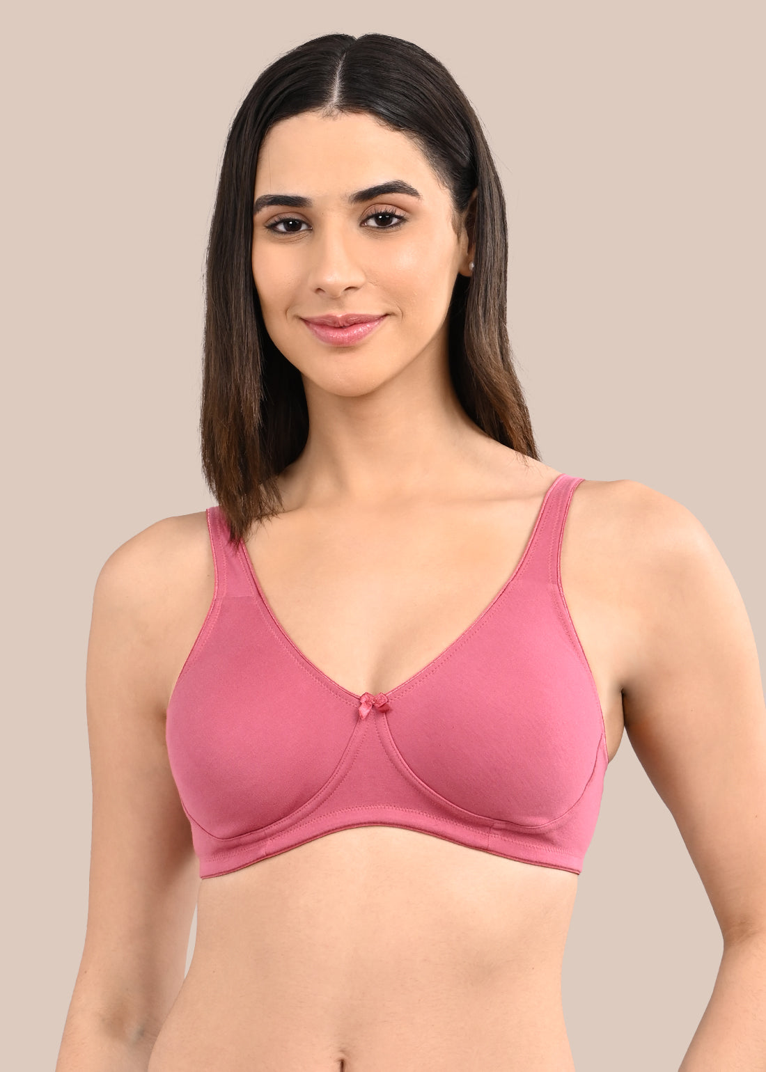 Woman wearing a bra against a neutral background