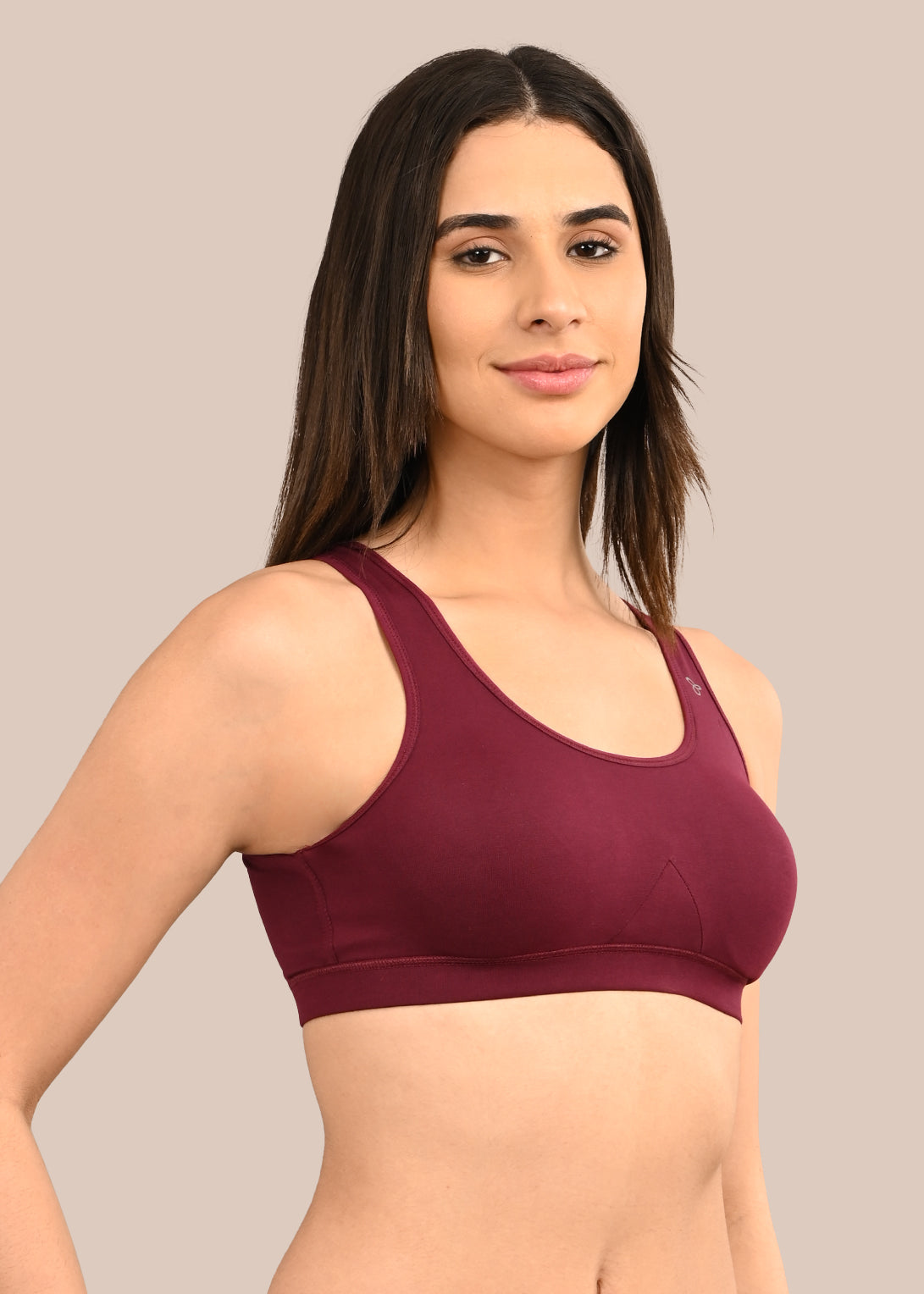 Woman wearing a bra against a neutral background