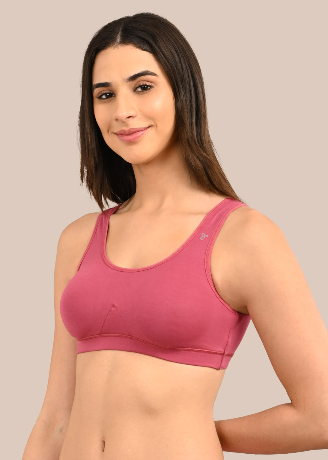 Woman wearing a bra against a neutral background