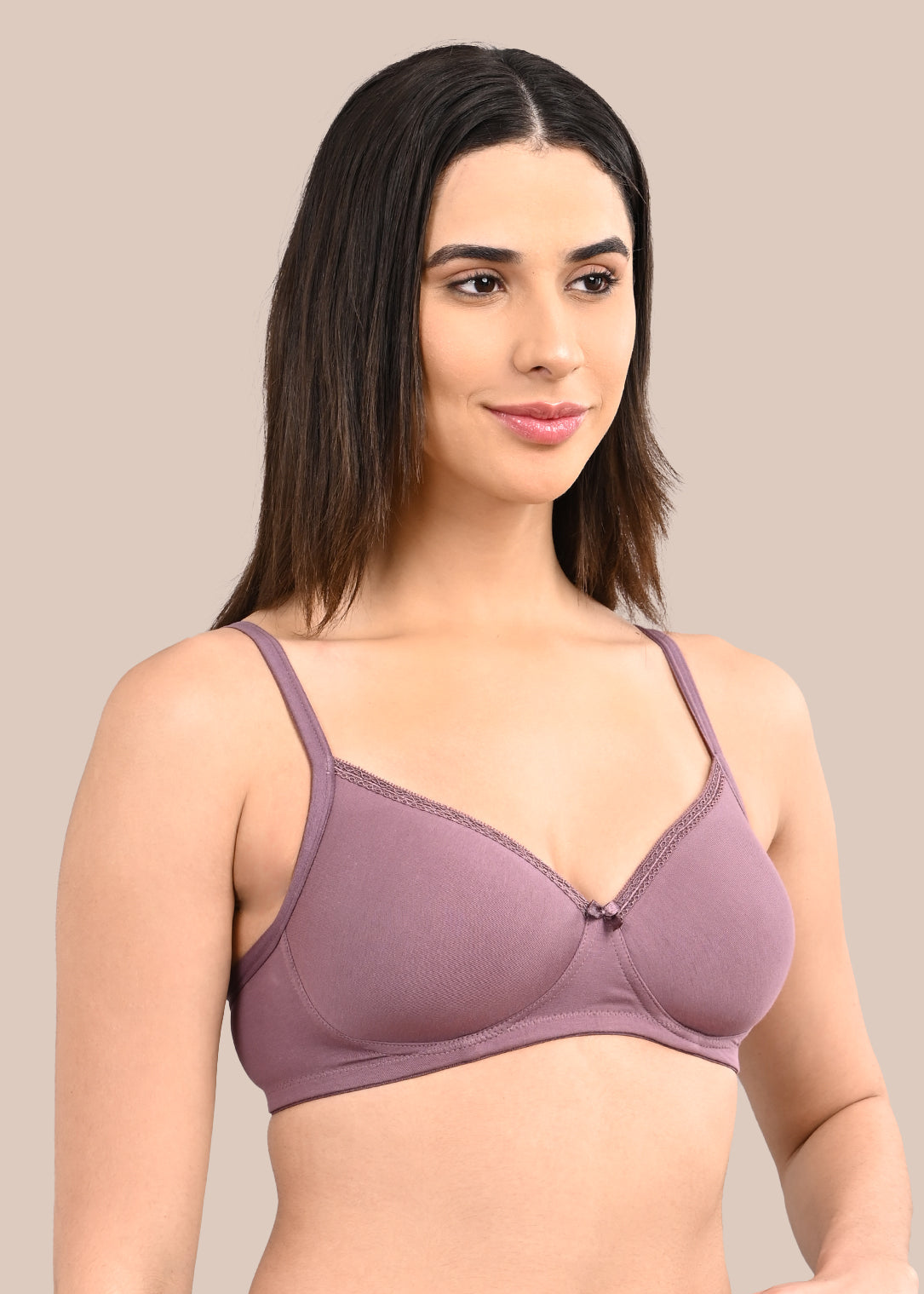 Woman wearing a bra against a neutral background