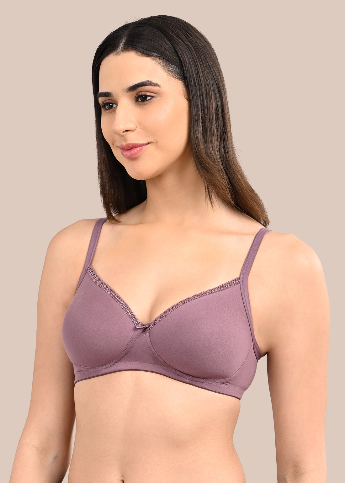 Woman wearing a bra against a neutral background