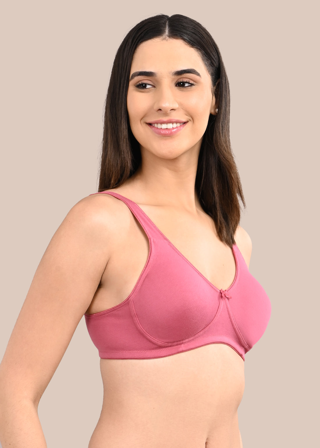 Woman wearing a bra against a neutral background