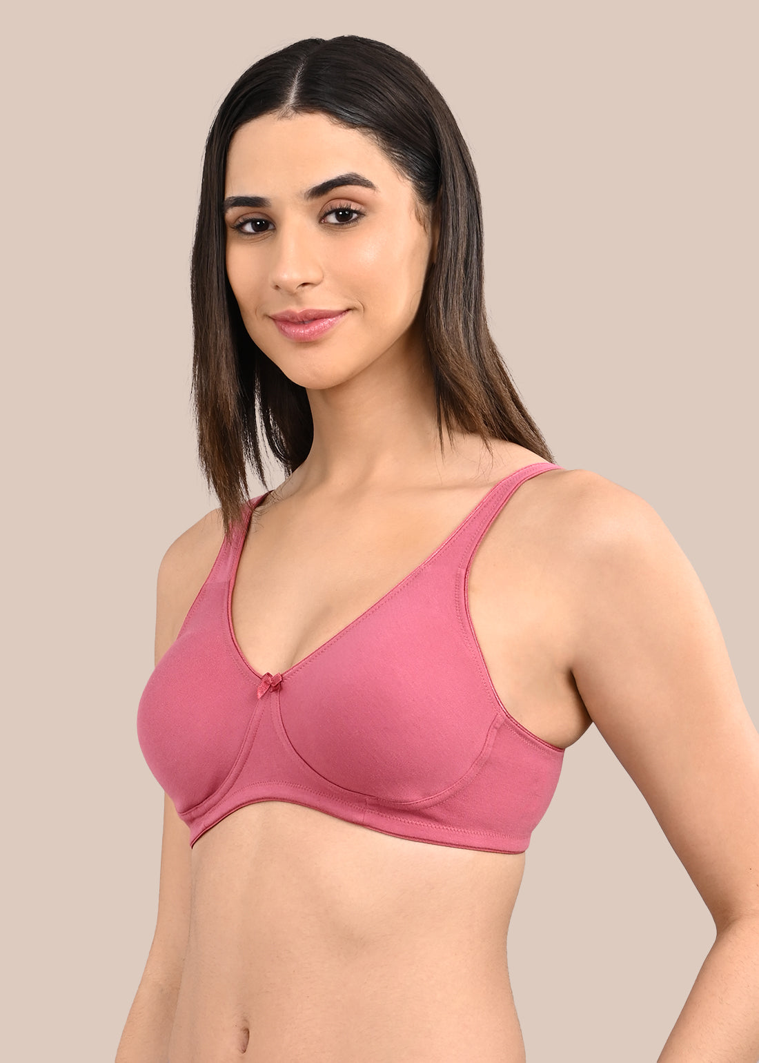 Woman wearing a bra against a neutral background