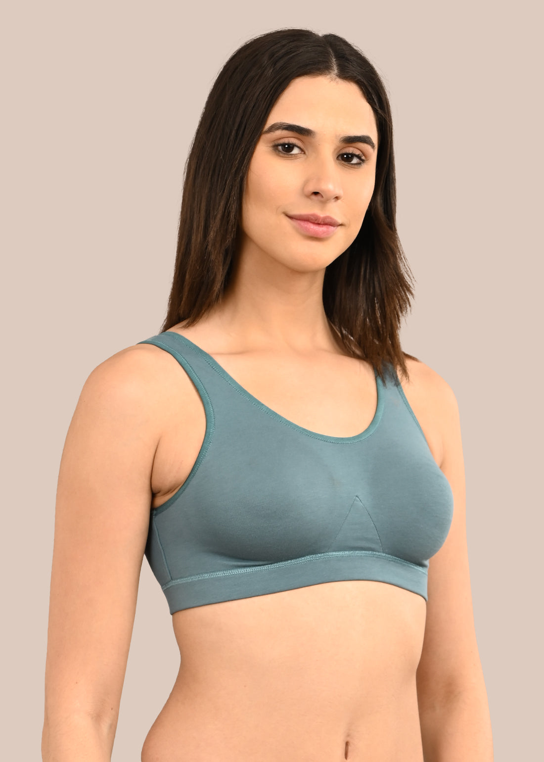 Woman wearing a bra against a neutral background